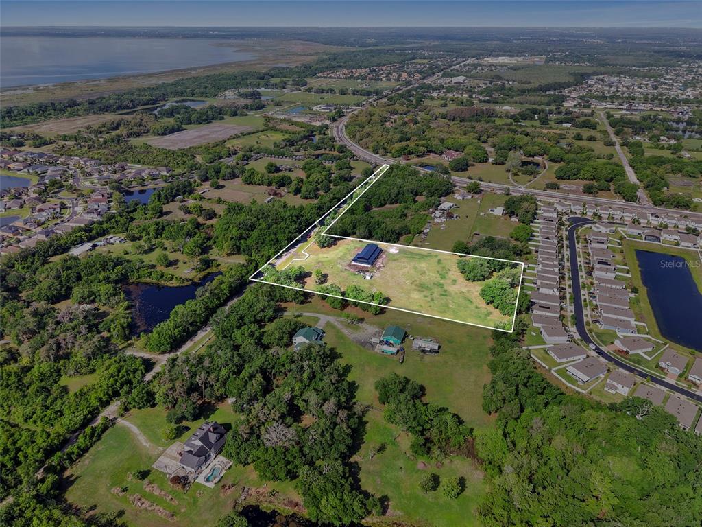 An aerial view shows a large, rectangular property outlined in white with a single building — 4355 SEMORAN FARMS ROAD, KISSIMMEE, FL