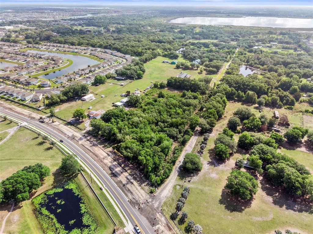 An aerial view shows a wooded lot adjacent to a road and residential neighborhood — 4355 SEMORAN FARMS ROAD, KISSIMMEE, FL