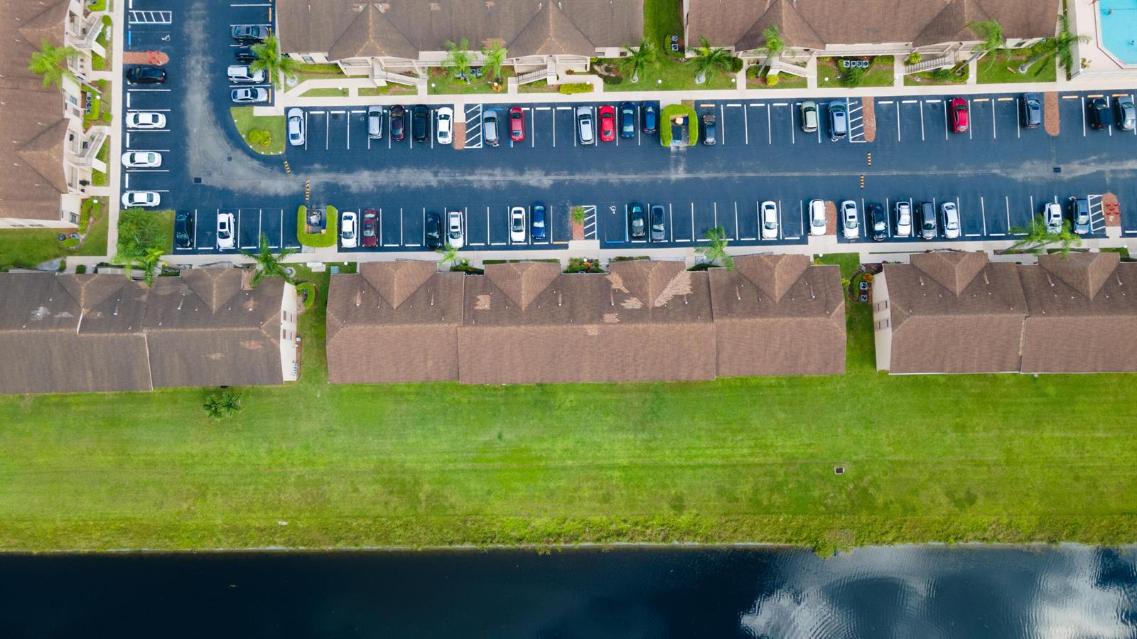 An aerial view shows a residential complex with parking spaces, apartment buildings, and a canal — 9467 Boca Cove Circle # 804, Boca Raton FL 33428, BOCA RATON, FL