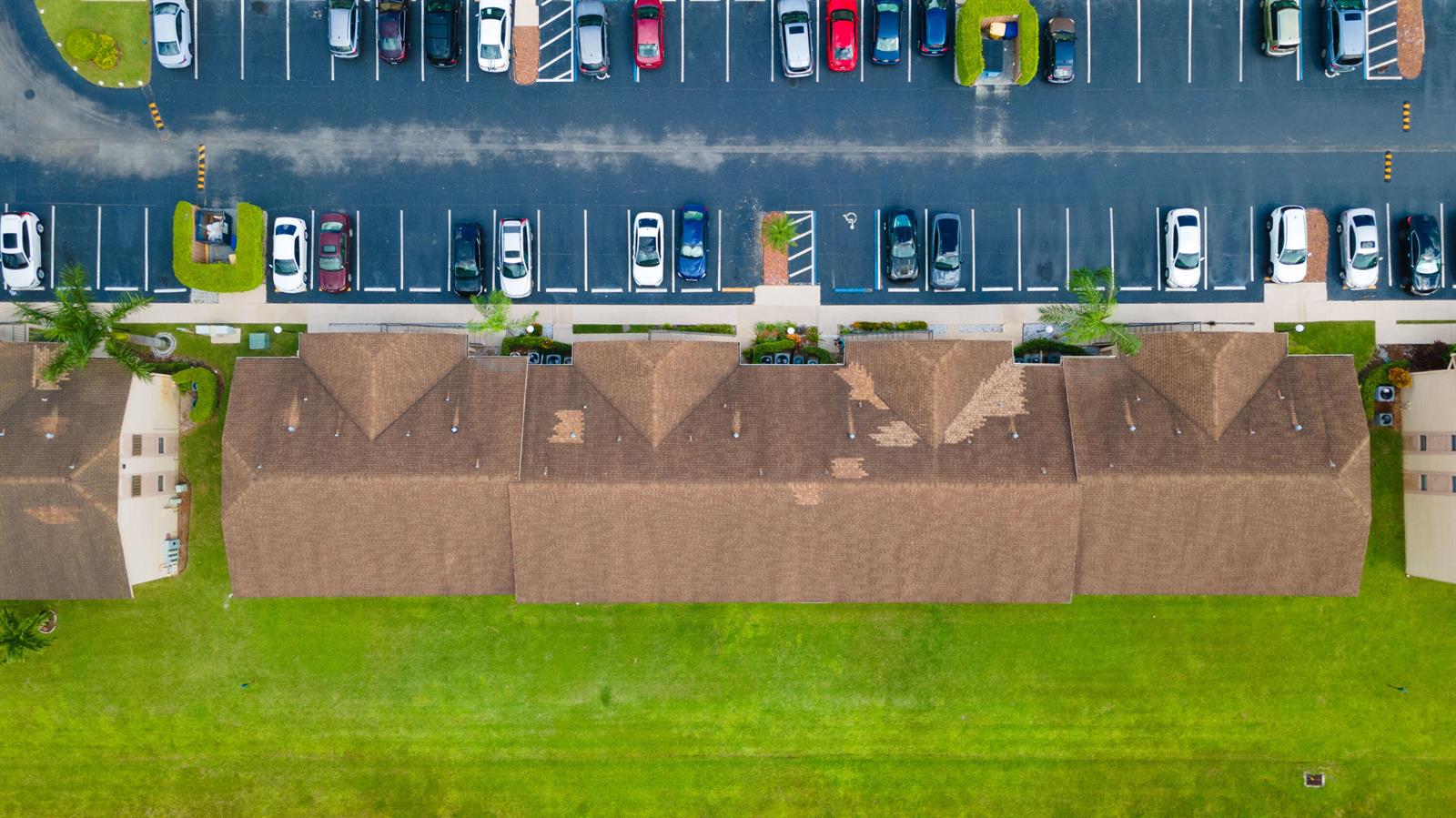 An aerial view shows a brown shingled apartment building with a parking lot and lawn — 9467 Boca Cove Circle # 804, Boca Raton FL 33428, BOCA RATON, FL