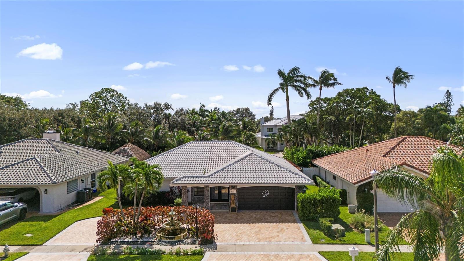 An aerial view shows a single-story house with a tiled roof and a paved driveway — 5223 Deerhurst Crescent Circle, Boca Raton FL 33486, BOCA RATON, FL