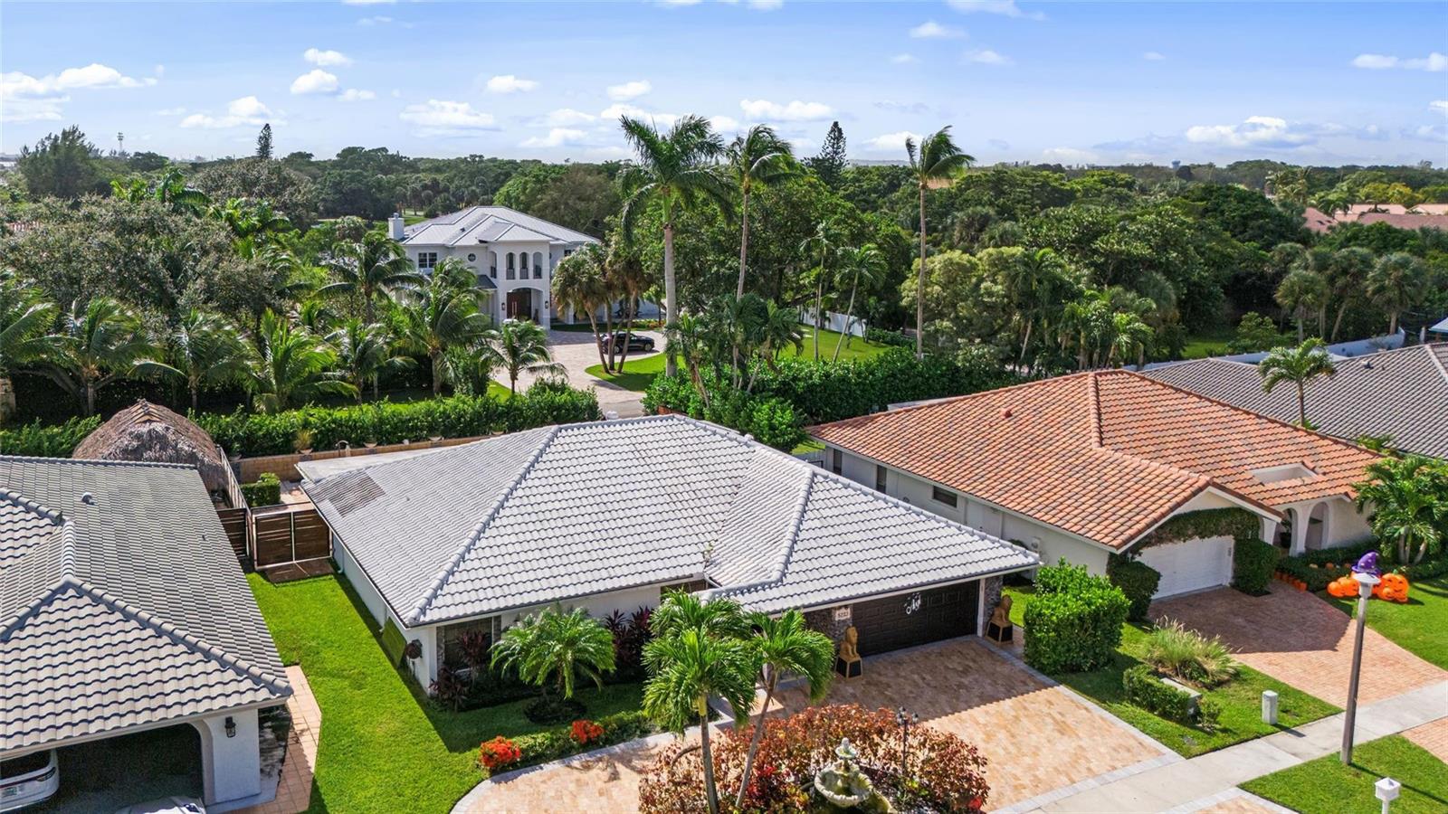 An aerial view shows several suburban houses with tiled roofs, palm trees, and landscaped yards — 5223 Deerhurst Crescent Circle, Boca Raton FL 33486, BOCA RATON, FL