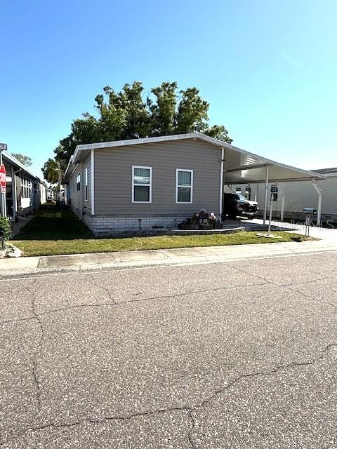A single-story manufactured home features gray siding, a carport, and a small front yard — 1001 STARKEY RD. LOT 731, LARGO, FL