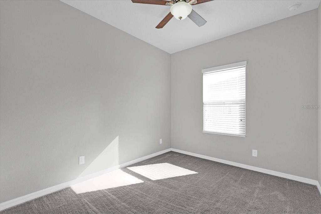 An empty bedroom features gray walls, gray carpeting, a ceiling fan, and a window with blinds — 1148 PALMA VERDE PLACE, APOPKA, FL