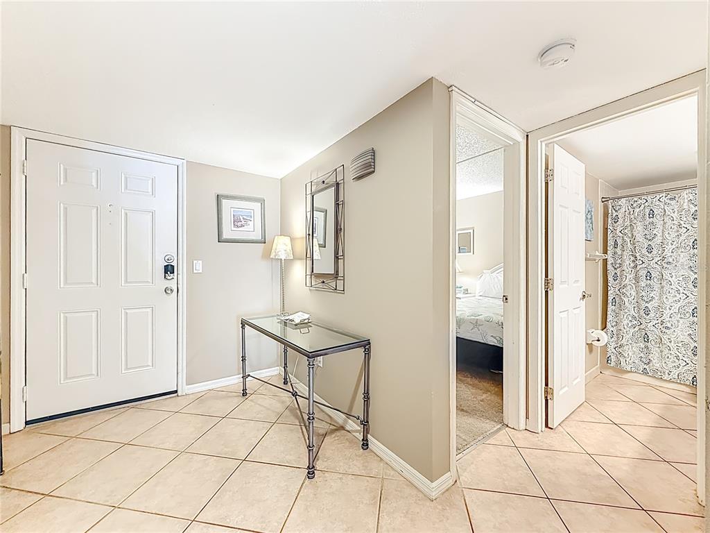 An entryway with tile flooring leads to a bedroom and a bathroom with a shower — 18400 GULF BOULEVARD UNIT 1312, INDIAN SHORES, FL