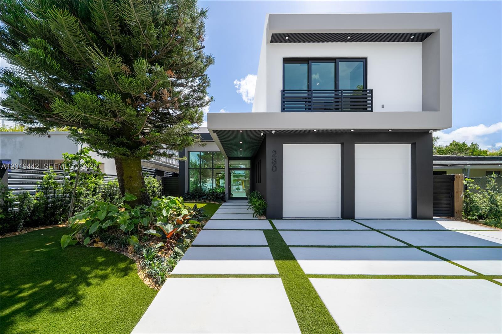 A modern two-story house features a white and gray facade, two garage doors, and landscaping — 280 NW 47th St, Miami FL 33127, MIAMI, FL