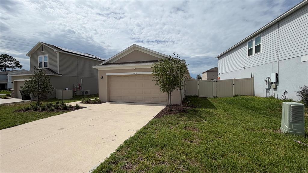 A beige single-story house with a two-car garage and a concrete driveway — 188 BRINSMEAD ROAD, HAINES CITY, FL