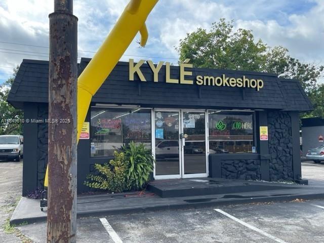 A black exterior building with gold signage for a smoke shop and a yellow inflatable — 6310 Pembroke Rd, Miramar FL 33023, MIRAMAR, FL