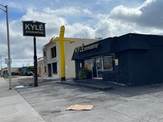 A yellow inflatable tube man stands in front of a black Kyle Smokeshop building — 6310 Pembroke Rd, Miramar FL 33023, MIRAMAR, FL