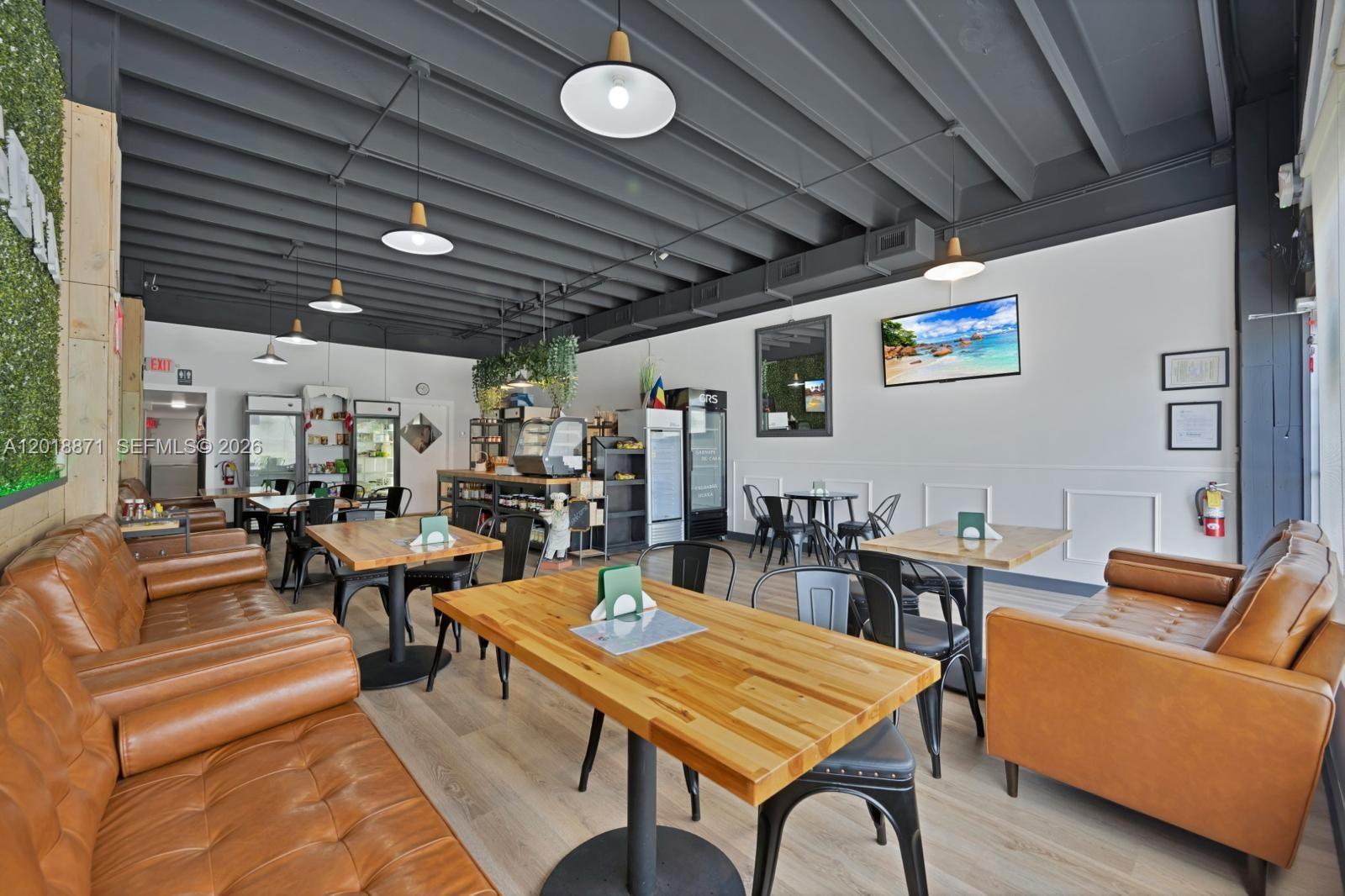 A restaurant interior features wooden tables, leather sofas, pendant lighting, and a dark ceiling — 422 S Dixie Hwy, Hollywood FL 33020, HOLLYWOOD, FL