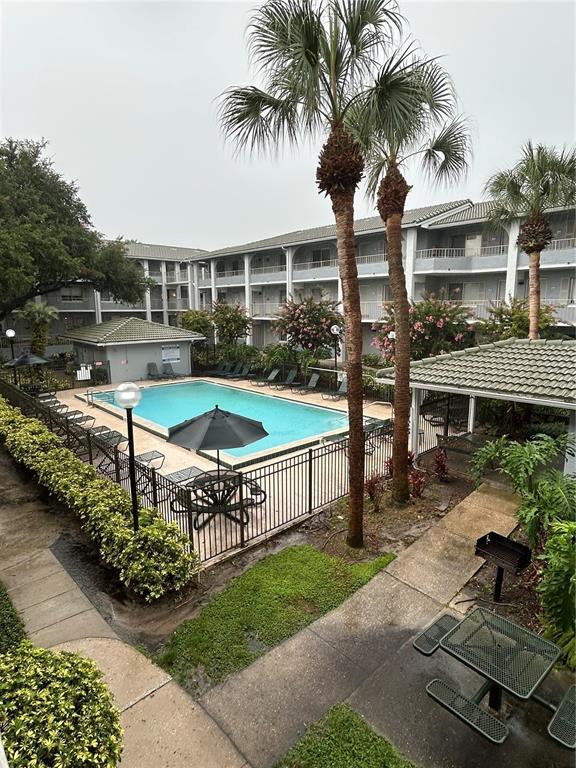 An outdoor swimming pool is surrounded by a patio, palm trees, and apartment buildings — 109 OYSTER BAY CIRCLE UNIT 240, ALTAMONTE SPRINGS, FL