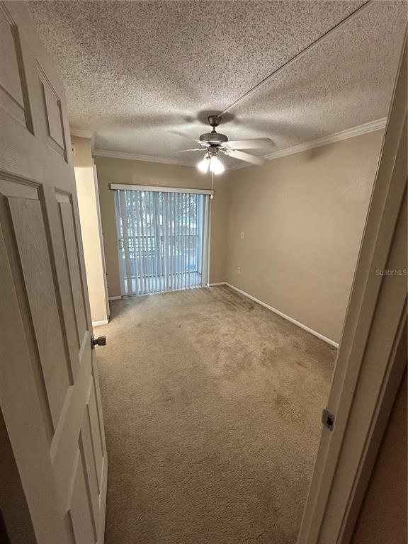 An empty bedroom with beige carpet, a ceiling fan, and sliding glass doors to a balcony — 109 OYSTER BAY CIRCLE UNIT 240, ALTAMONTE SPRINGS, FL