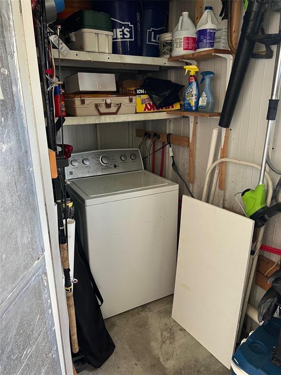 A utility closet contains a top-loading washing machine, storage shelving, and various household items — 142 FERN PALM STREET, LARGO, FL