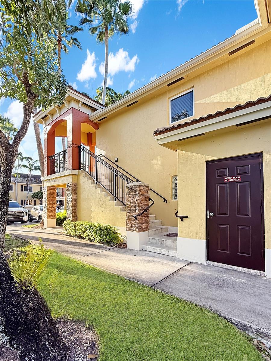 An exterior view shows a yellow building with a brown door labeled meter room — 945 NE 34th Ave # 204, Homestead FL 33033, HOMESTEAD, FL