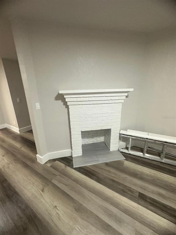 A room features a white painted brick fireplace with a gray tiled hearth and wood-look flooring — 1150 PIPPIN STREET, JACKSONVILLE, FL