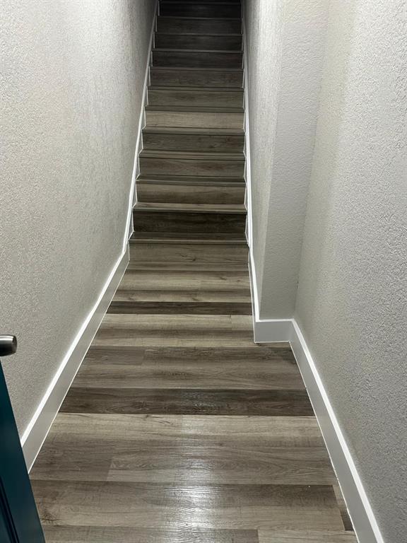 A narrow hallway with wood-look flooring leads to a set of stairs — 1150 PIPPIN STREET, JACKSONVILLE, FL