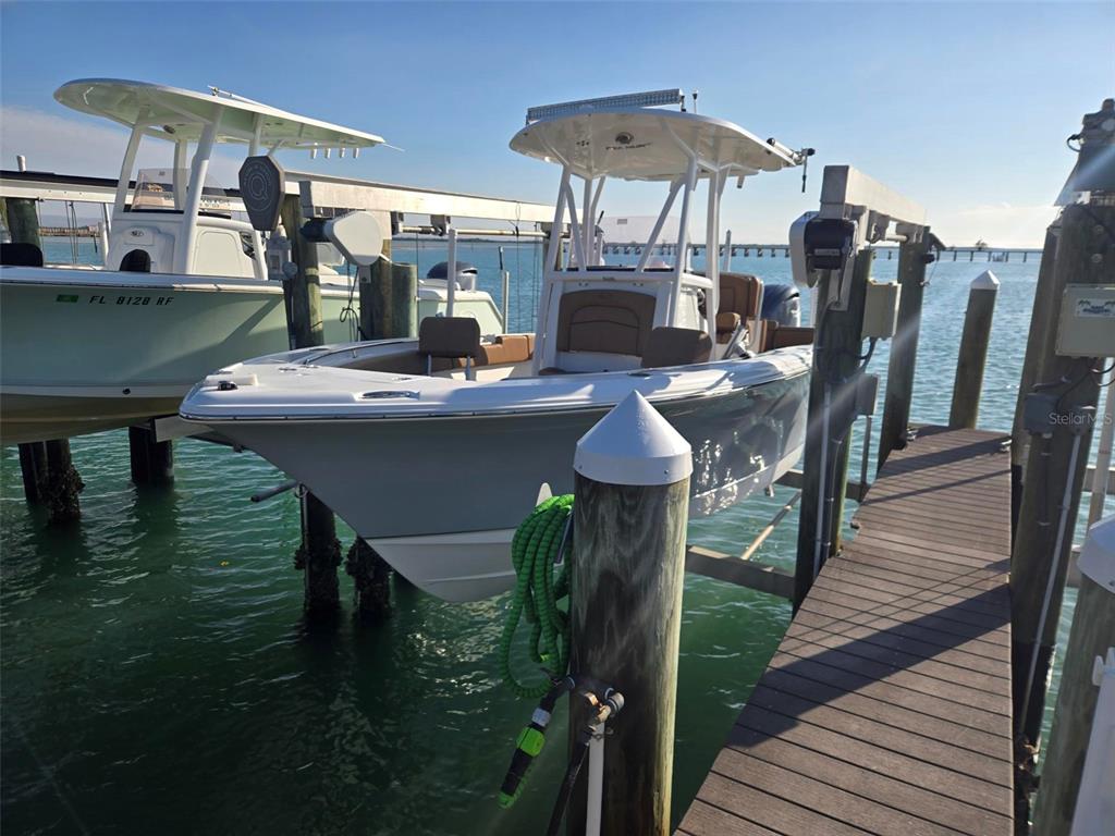 Two center console boats are docked at a wooden pier on a sunny day — 6040 BOCA GRANDE CAUSEWAY UNIT 03 Boat Slip, BOCA GRANDE, FL