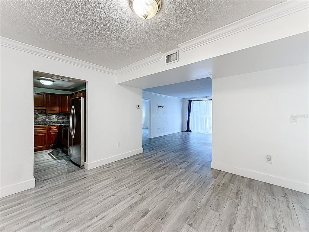 A view from a living area looking into a kitchen and a secondary room — 12500 NE 15TH AVENUE UNIT 105, NORTH MIAMI, FL