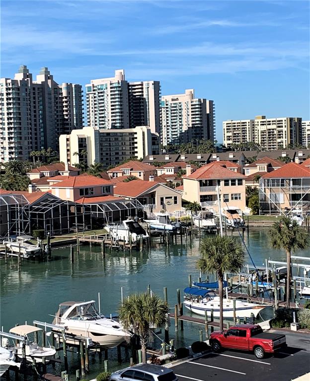 A view of a marina with boats docked in front of residential buildings and high-rises — 240 SAND KEY ESTATES DRIVE UNIT 257, CLEARWATER, FL