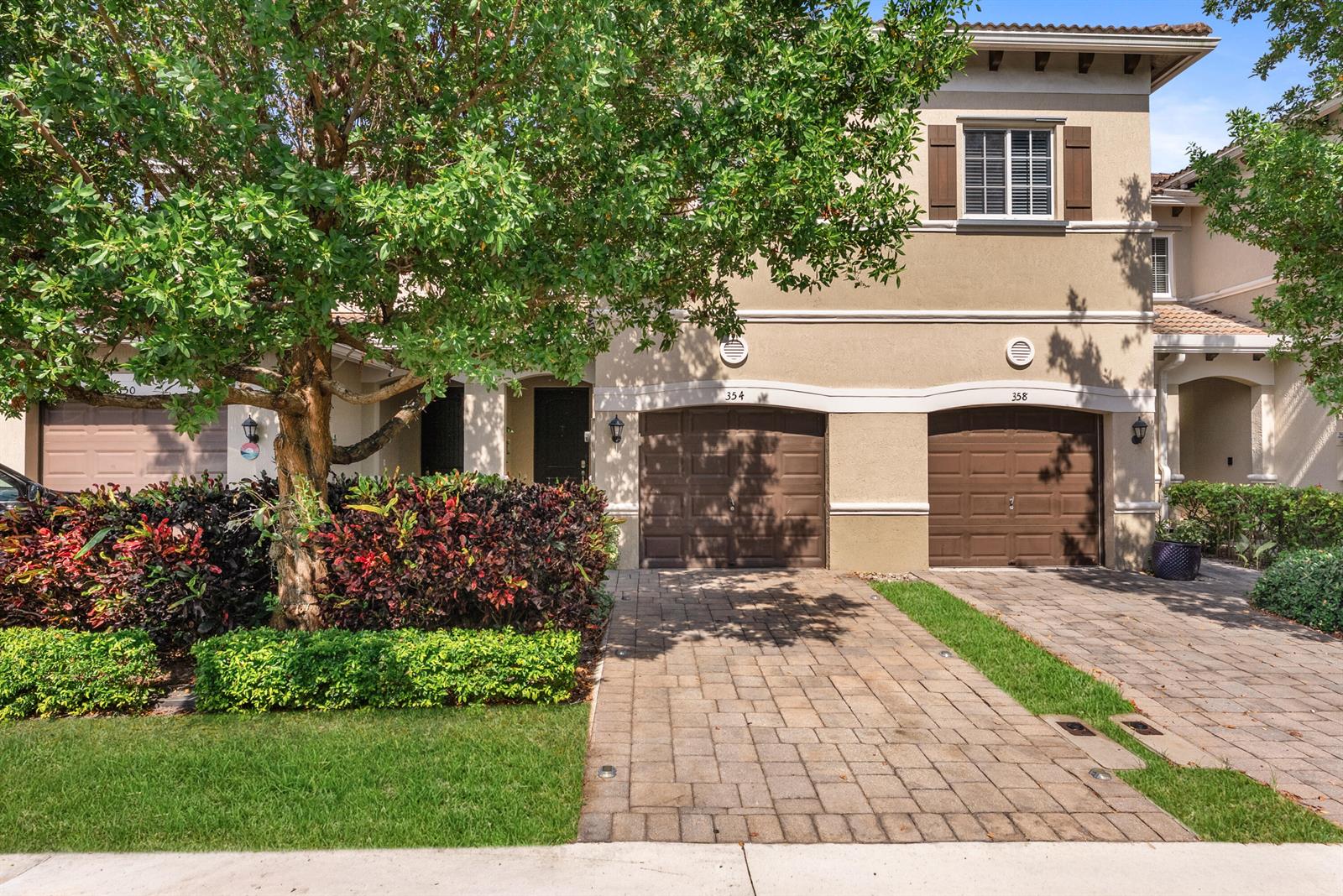 An exterior view of a two-story townhouse with two brown garages and a paved driveway — 354 SE 1st Way # 354, Deerfield Beach FL 33441, DEERFIELD BEACH, FL