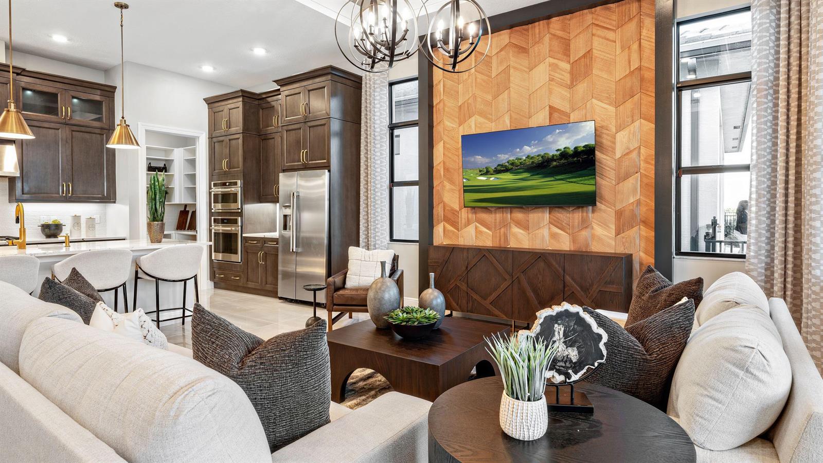 A modern living room features a chevron wood accent wall, dark cabinetry, and neutral furniture — 5627 Saint Armands Way, Westlake FL 33470, WESTLAKE, FL