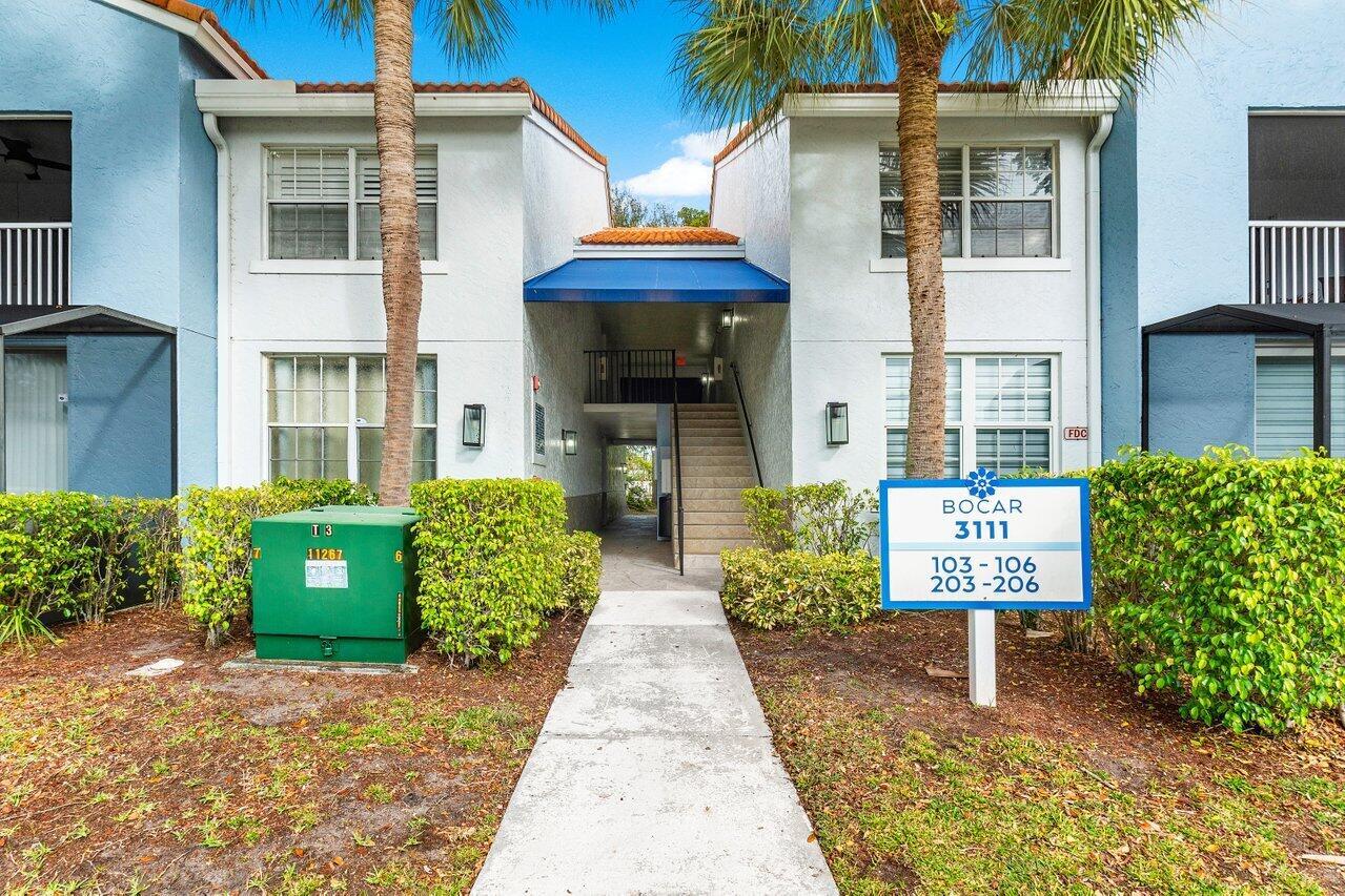 A sidewalk leads to the entrance of a two-story apartment building with blue accents — 3111 Clint Moore Road, Boca Raton FL 33496, BOCA RATON, FL