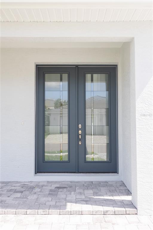 A dark gray double front door with glass panels sits under a white covered entryway — 5240 WILLOW LAKE COURT, SARASOTA, FL