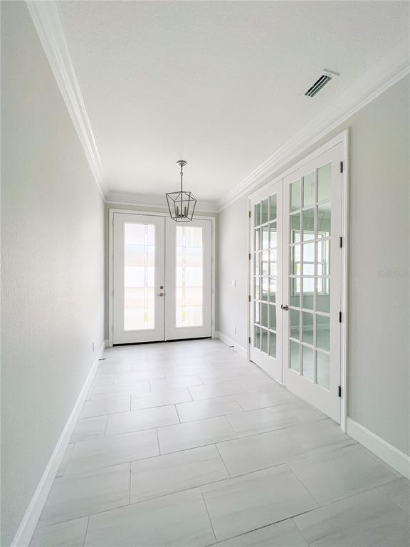 A bright entryway features light-colored tile flooring, white walls, a pendant light, and French doors — 5240 WILLOW LAKE COURT, SARASOTA, FL