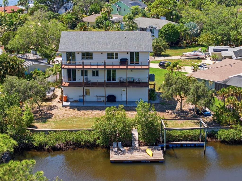 An aerial view of a three-story house with two balconies and a private wooden dock — 1130 S FLORIDA AVENUE, TARPON SPRINGS, FL