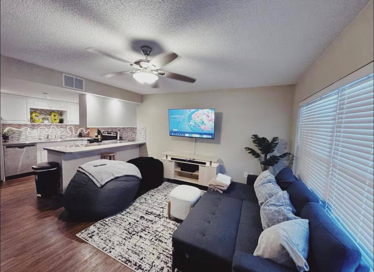 A living room with a sofa, beanbag chairs, a television, and an open kitchen area — 108 Lacosta Lane # 611, FL 32114, FL