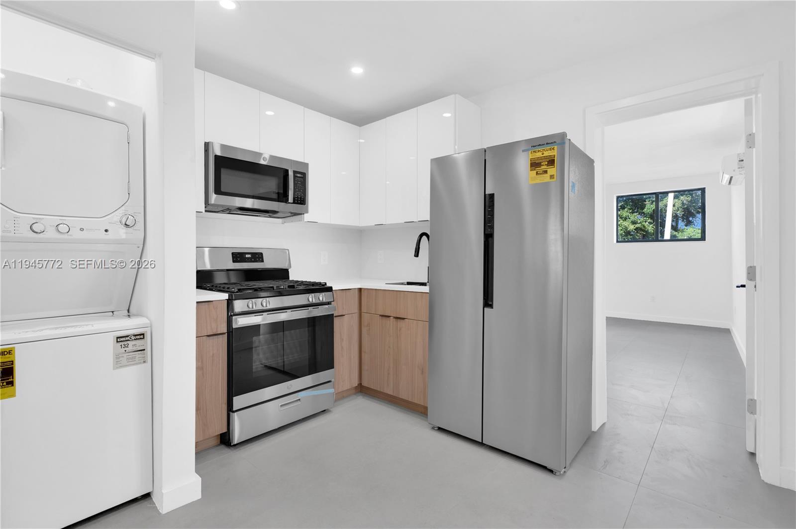A kitchen features stainless steel appliances, white upper cabinets, and light wood lower cabinets — 3040 NW 93rd St # A, Miami FL 33147, MIAMI, FL