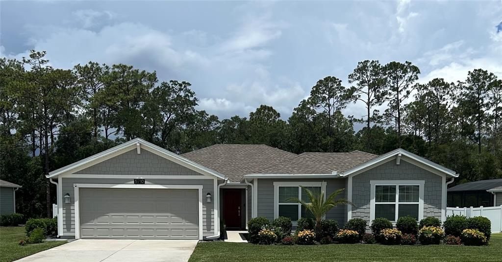 A single-story house with a gray exterior, shingled roof, and a two-car garage — 5710 ALENLON WAY, MOUNT DORA, FL