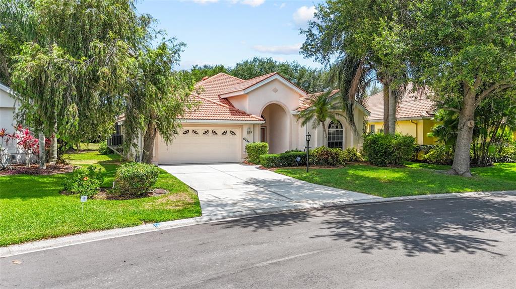 A single-story house with a beige stucco exterior, a tiled roof, and a concrete driveway — 6223 DONNINGTON COURT, SARASOTA, FL