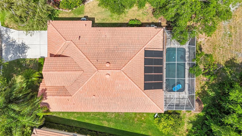 An aerial view shows a house with a tiled roof, solar panels, and a screened pool — 6223 DONNINGTON COURT, SARASOTA, FL