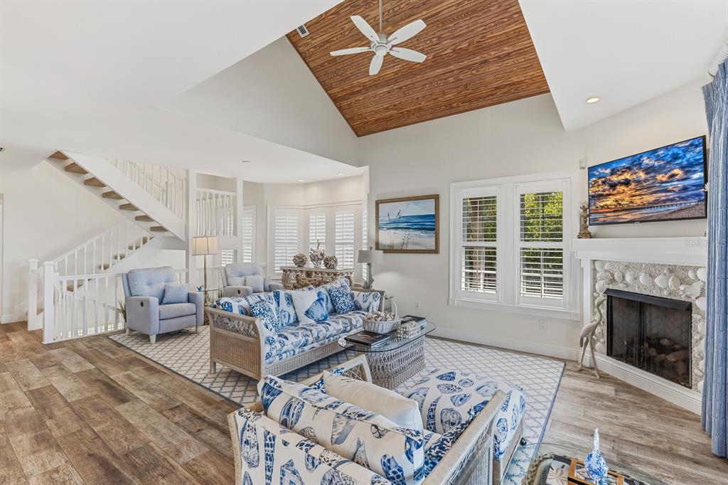 A living room features a vaulted wood ceiling, a shell-covered fireplace, and water views — 40 SEAWATCH LAKE DRIVE, BOCA GRANDE, FL
