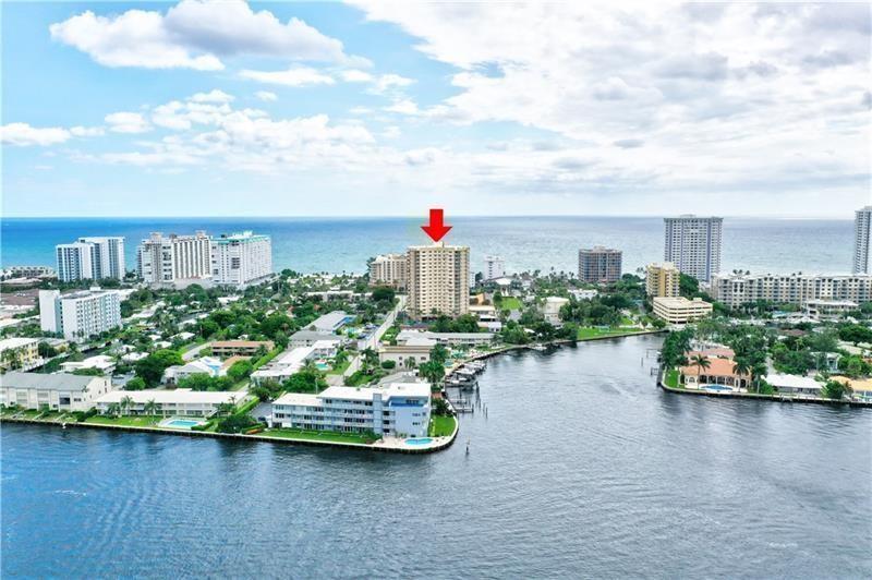An aerial view shows a tall apartment building marked by a red arrow near water — 1200 Hibiscus Avenue # 702, Pompano Beach FL 33062, POMPANO BEACH, FL