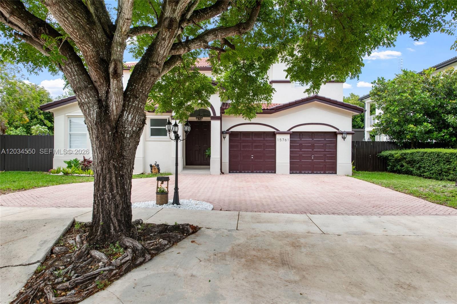 A two-story house with a two-car garage, a paved driveway, and a large tree — 15761 SW 59th Ter, Miami FL 33193, MIAMI, FL