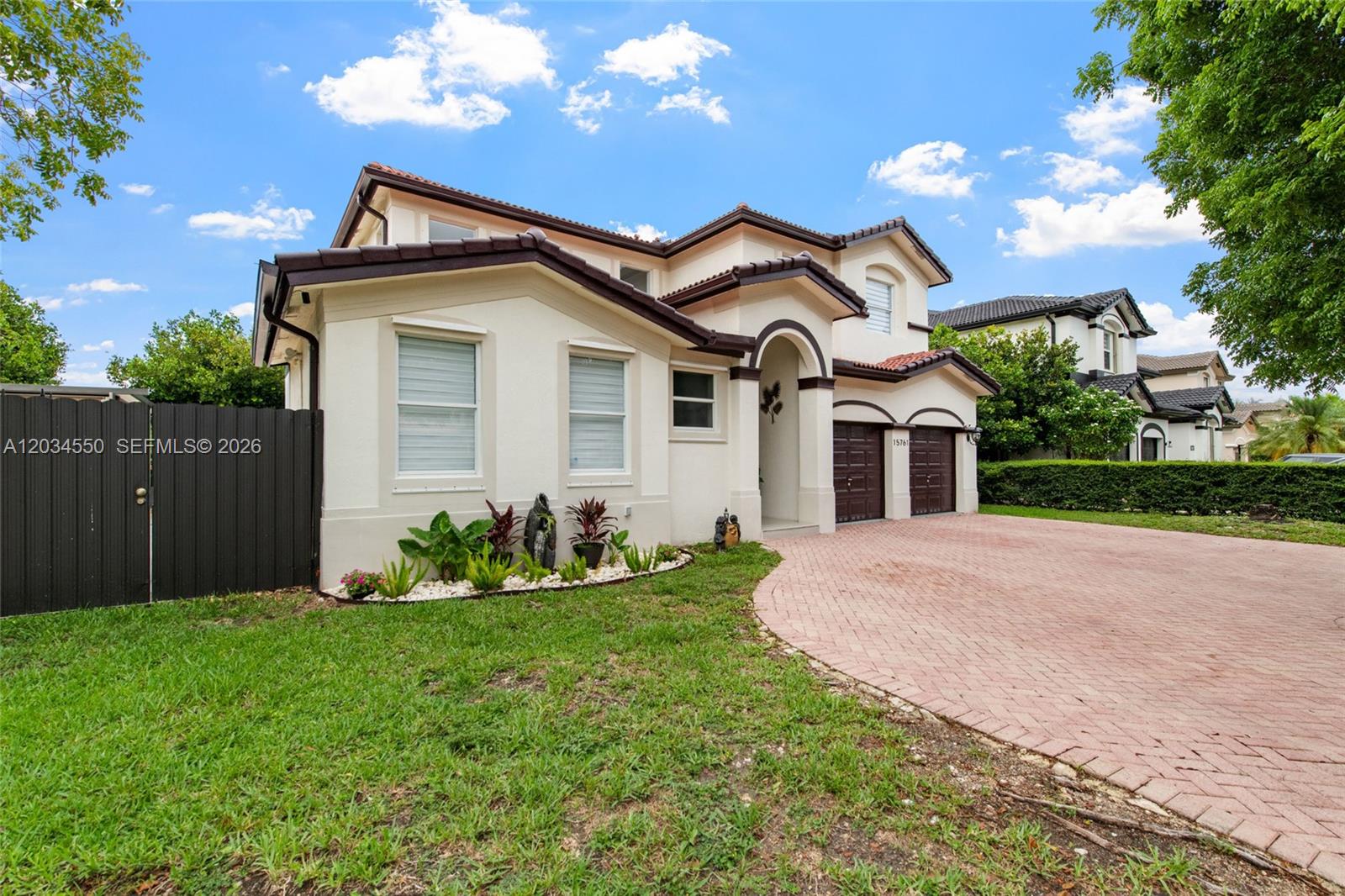 A two-story house with a paved driveway, a two-car garage, and a fenced side yard — 15761 SW 59th Ter, Miami FL 33193, MIAMI, FL