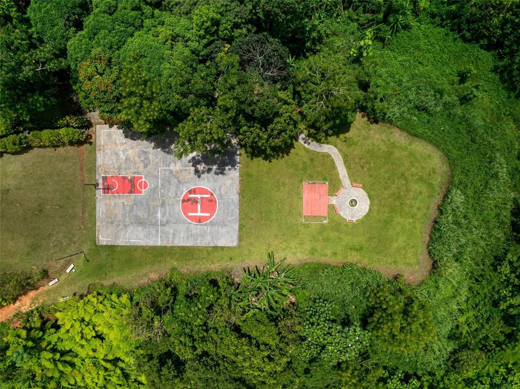 An aerial view shows a basketball court with a helipad marking and a nearby patio area — PR 797 km 5.3 JAGUEYES WARD, AGUAS BUENAS, PR