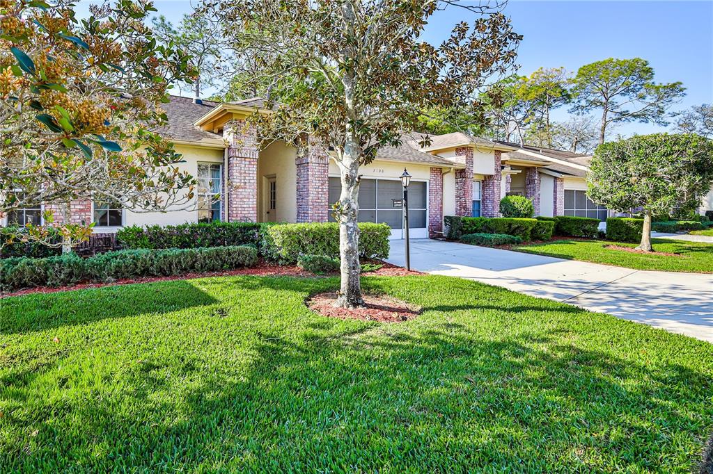 A single-story house with a brick facade, a two-car garage, and a manicured front lawn — 3100 APPLEBLOSSOM TRAIL, SPRING HILL, FL