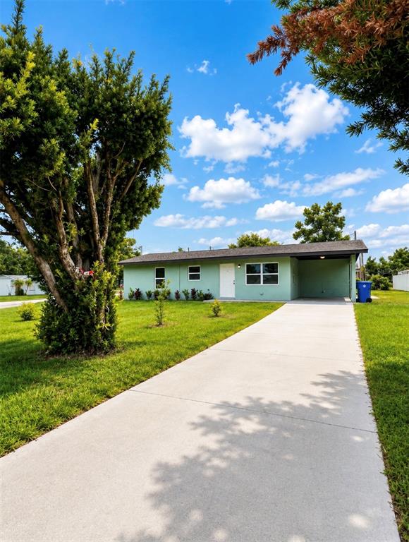 A light green single-story house features a concrete driveway and a covered carport — 401 MORNINGSIDE, VALRICO, FL