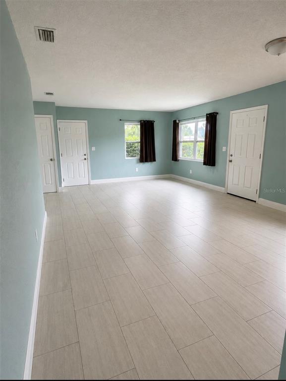 An empty room with light blue walls, tile flooring, and two white doors — 401 MORNINGSIDE, VALRICO, FL
