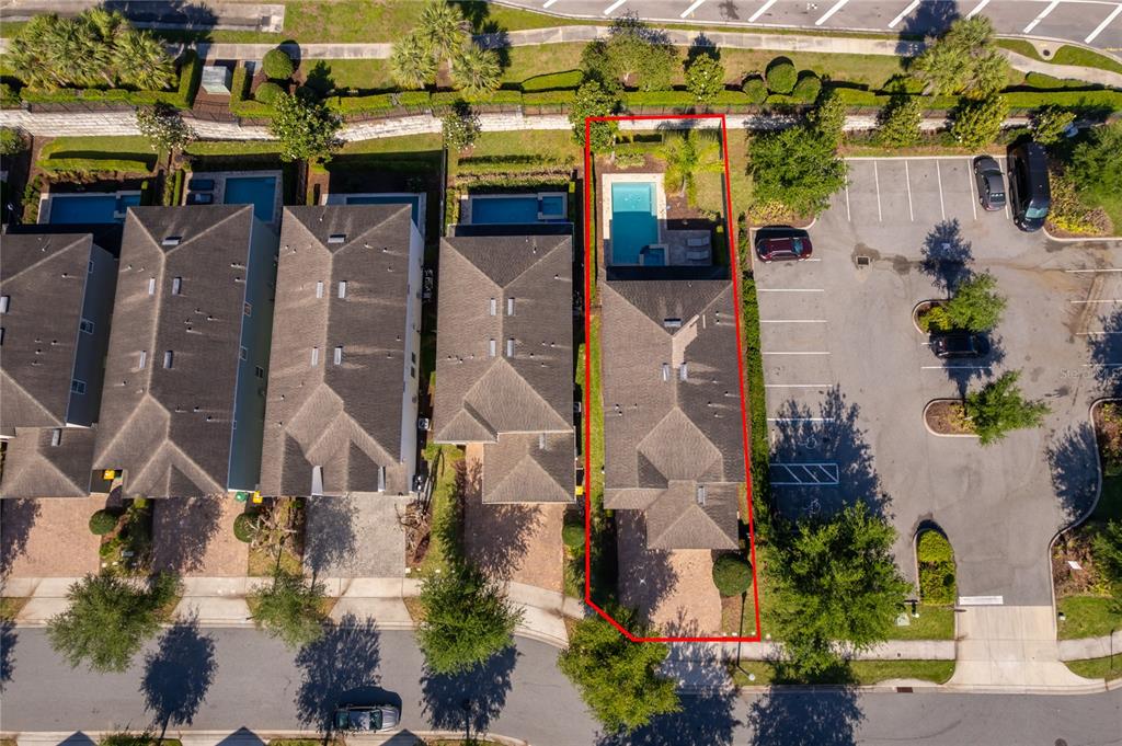 An aerial view shows a residential house with a private pool and adjacent parking lot — 380 PENDANT COURT, KISSIMMEE, FL