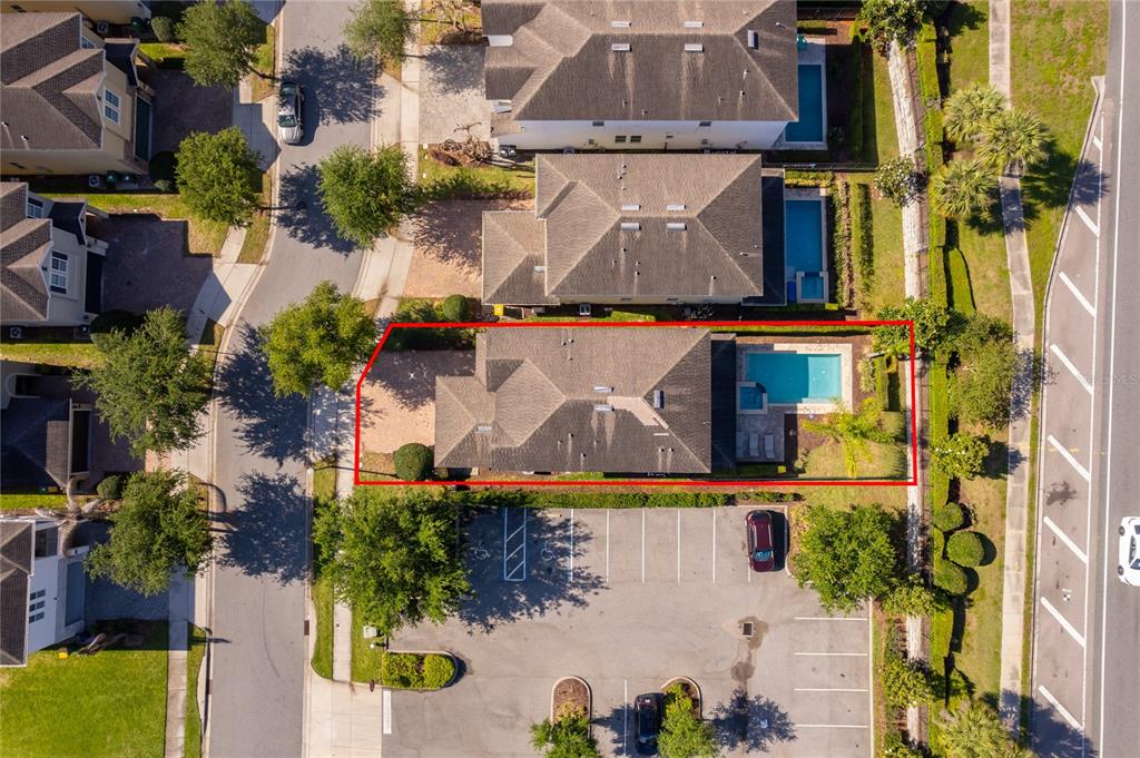 An aerial view shows a residential house with a swimming pool and adjacent parking lot — 380 PENDANT COURT, KISSIMMEE, FL