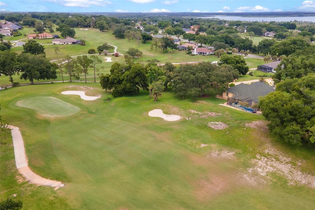 An aerial view of a golf course fairway with sand traps and nearby residential homes — 5506 CITATION COURT, LADY LAKE, FL