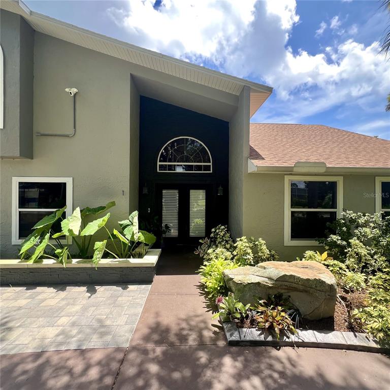 The exterior of a house features a dark entryway with a semi-circular window above doors — 1 HARRIS CIRCLE, EDGEWATER, FL