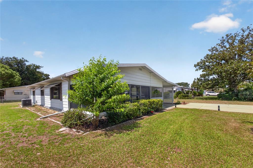 A single-story house with white siding and a screened-in porch sits on a grassy lot — 8972 SW 103RD LANE, OCALA, FL