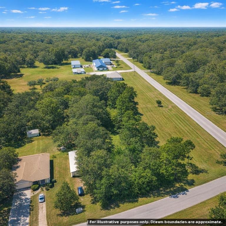 An aerial view shows a rural property with houses, outbuildings, and trees along a road — FLAMINGO ROAD, OAK HILL, FL