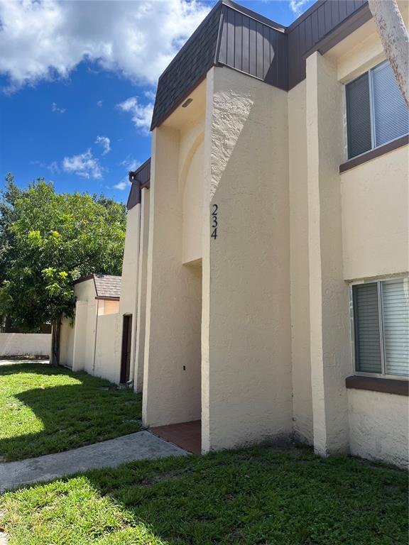 A two-story tan stucco building with a recessed entryway and dark brown trim — 234 KRIDER ROAD, SANFORD, FL