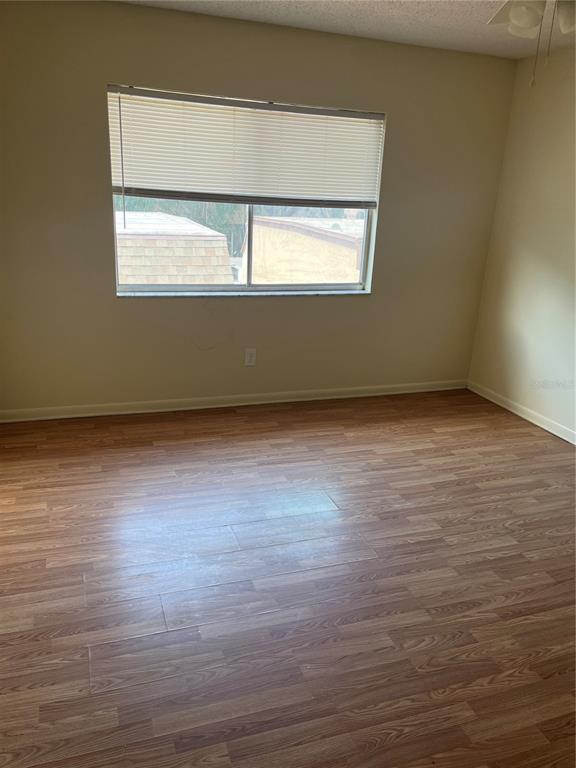 An empty bedroom features light-colored walls, wood-look laminate flooring, and a window with blinds — 234 KRIDER ROAD, SANFORD, FL